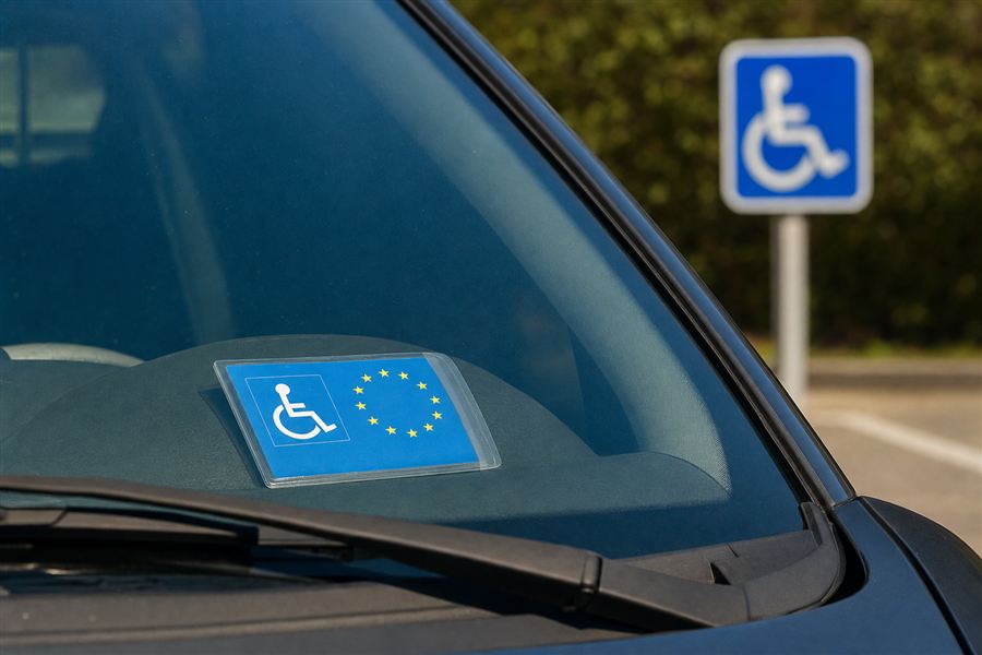 Speciale kaart voor personen met een handicap achter de voorruit, bij het bord met het symbool