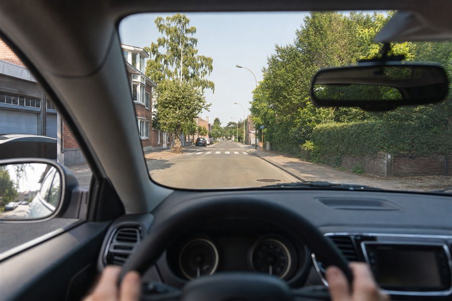 Bestuurder die ver, opzij en achter zich kijkt om de weg te lezen