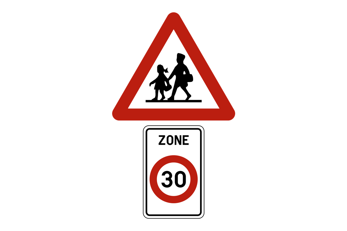 Gevaarsbord voor een plaats waar veel kinderen komen, boven het beginbord van een zone 30: samen duiden ze een schoolomgeving aan.