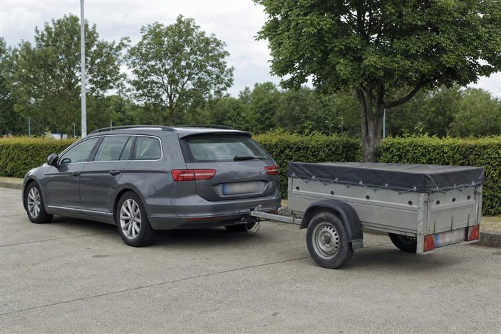 Auto met een lichte, afgedekte aanhangwagen eraan gekoppeld