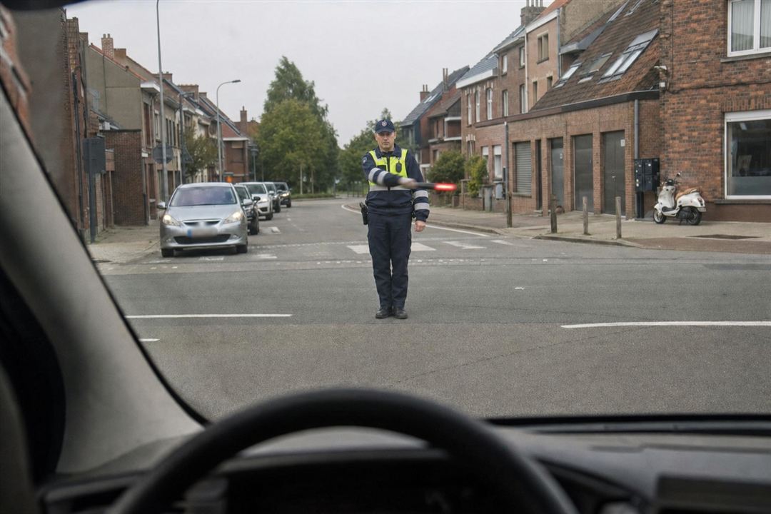 Bevoegd persoon zwaait overdwars met een rood licht, gezien door de voorruit