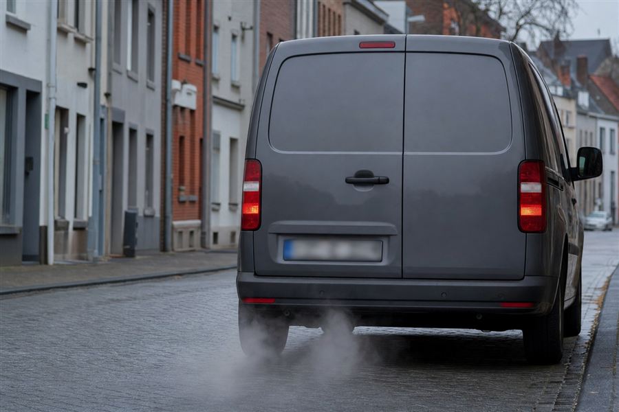 Vrachtwagen die stilstaat met draaiende motor en een dikke rookwolk