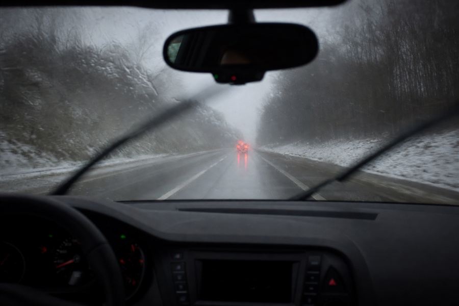 Zicht vanuit de auto bij regen en sneeuw op de voorruit